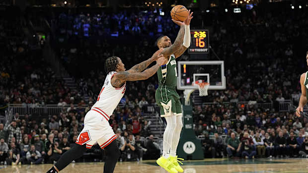 Chicago Bulls guard Coby White (0) shoots behind Chicago Bulls forward DeMar DeRozan (11) 
